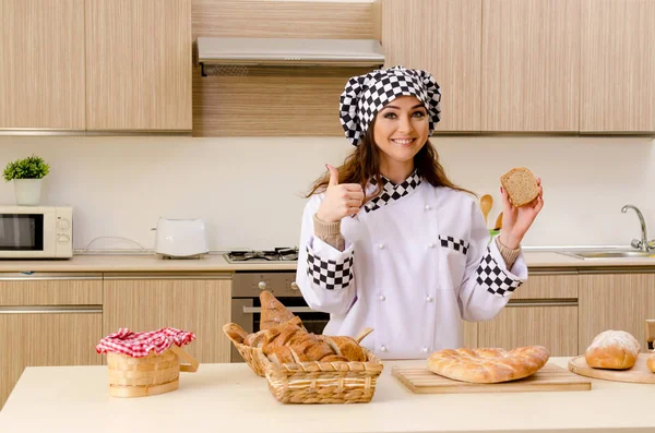 Young female baker working in kitchen — Stock Photo, Image