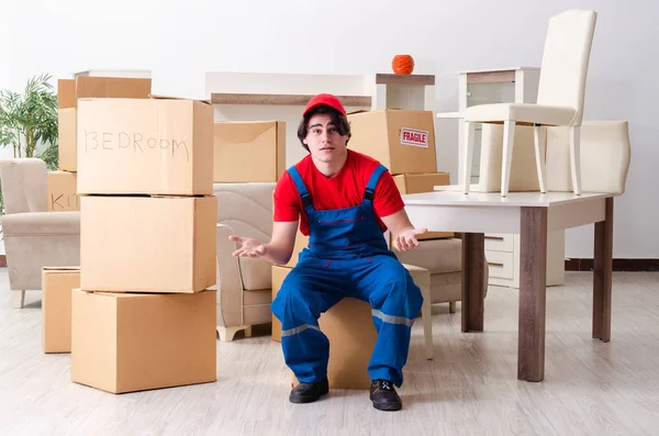 Joven contratista masculino con cajas trabajando en interiores — Foto de Stock