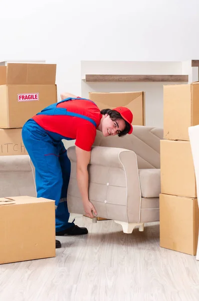 Joven contratista masculino con cajas trabajando en interiores —  Fotos de Stock