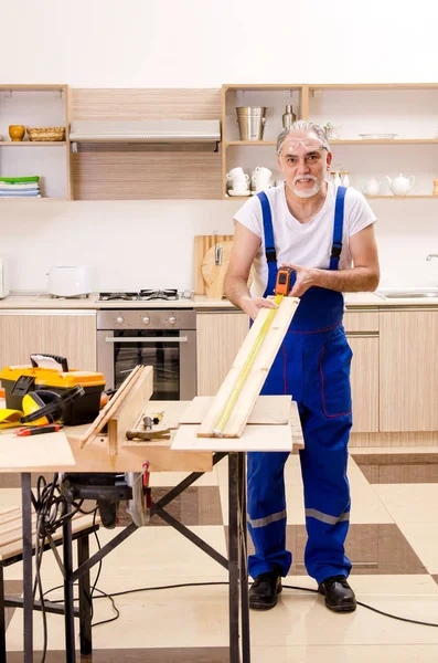 Impiegato anziano riparatore che lavora in cucina — Foto Stock