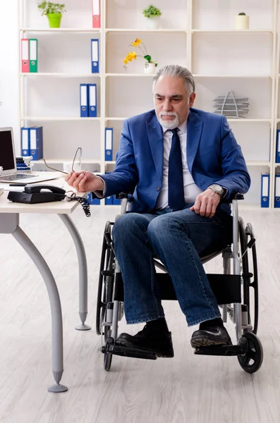 Älterer Mitarbeiter im Rollstuhl arbeitet im Büro — Stockfoto