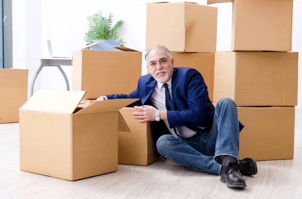 Betagter Geschäftsmann zieht an neuen Arbeitsplatz — Stockfoto