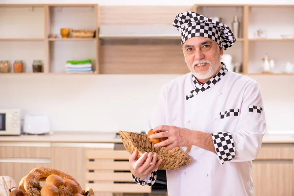 Viejo panadero trabajando en la cocina — Foto de Stock