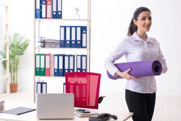 Joven empleada haciendo ejercicios en la oficina — Foto de Stock