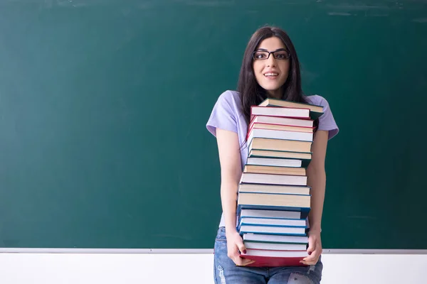 Jovem estudante professora na frente do quadro verde — Fotografia de Stock