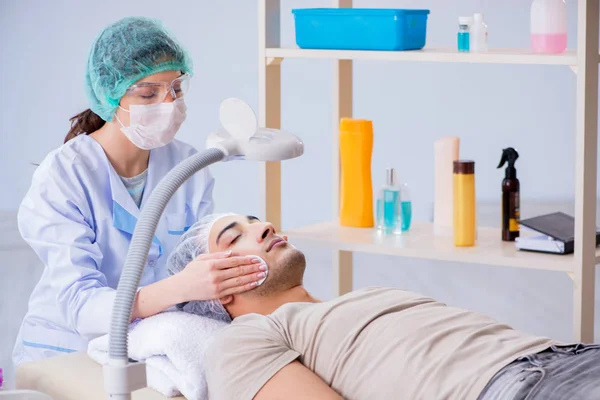 Jovem homem bonito visitando médico cosmetologista feminino — Fotografia de Stock