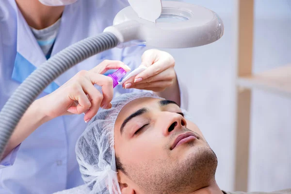 Jovem homem bonito visitando médico cosmetologista feminino — Fotografia de Stock