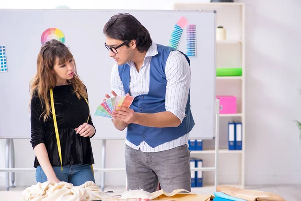 Young male tailor teaching female student — Stock Photo, Image