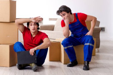 İki genç müteahhit kişisel eşyalarını taşıyor.