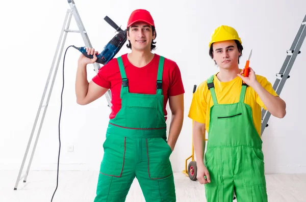 Dois trabalhadores empreiteiros que trabalham dentro de casa — Fotografia de Stock