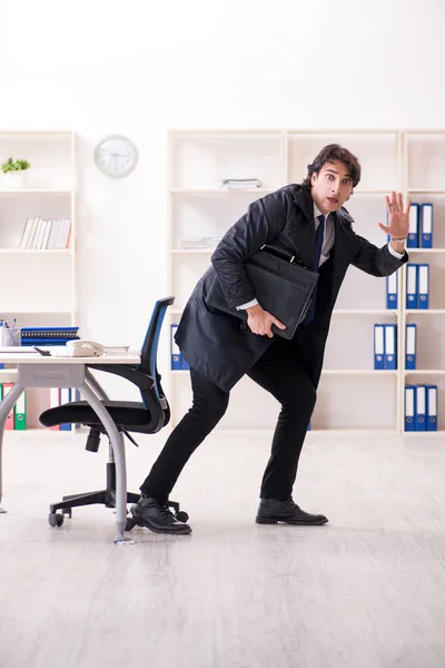 Ung manlig anställd på kontoret i time management koncept — Stockfoto