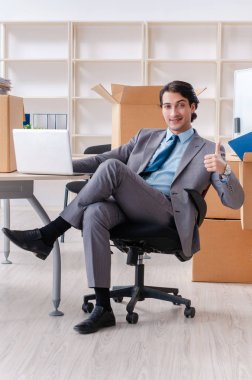 Genç adam çalışan ofiste kutuları ile 