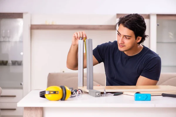 Young man repairing furniture at home