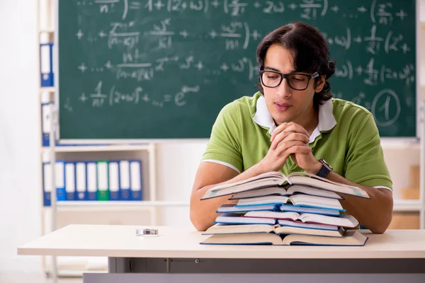 Estudiante guapo delante de pizarra con fórmulas — Foto de Stock