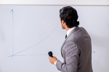 Genç yakışıklı iş adamı beyaz tahtanın önünde 