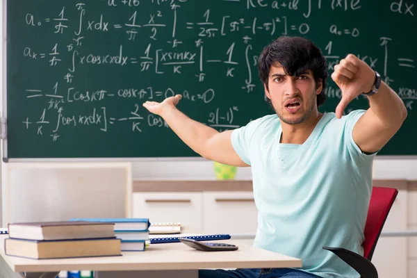 Mladý muž student matematik před tabuli — Stock fotografie