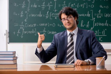 Genç erkek matematik öğretmeni sınıfta 