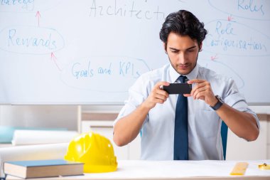 Genç erkek mimar beyaz tahtanın önünde. 