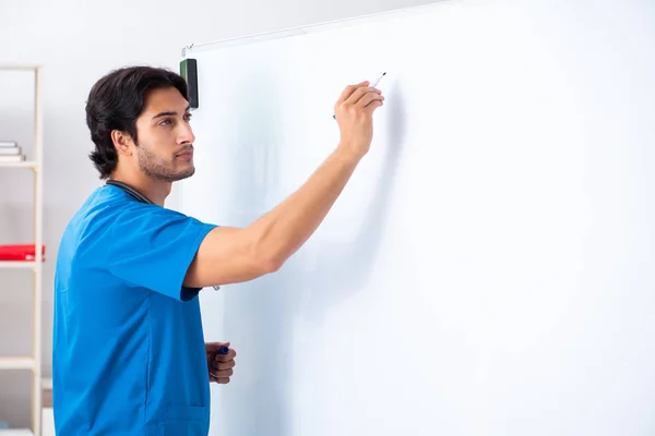 Jonge mannelijke arts voor het whiteboard — Stockfoto