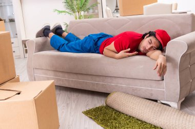 İçeride çalışan kutularla çalışan genç bir erkek müteahhit. 