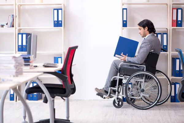 Giovane bel dipendente in sedia a rotelle che lavora in ufficio — Foto Stock