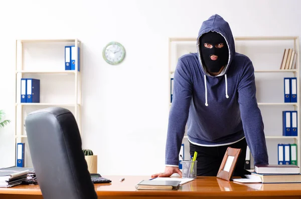 Männlicher Dieb mit Sturmhaube im Büro — Stockfoto