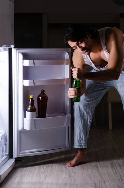 Homme rompant le régime la nuit près du réfrigérateur — Photo