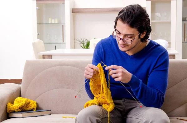 Młody przystojny mężczyzna robi na drutach w domu — Zdjęcie stockowe