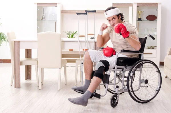 Injured young man doing exercises at home — Stock Photo, Image