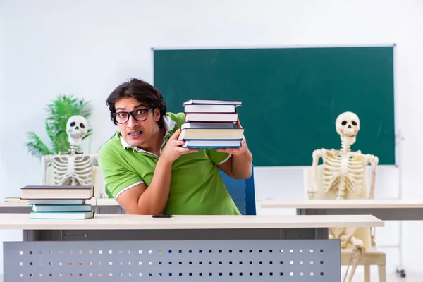 Divertente studente maschio in classe con scheletro — Foto Stock