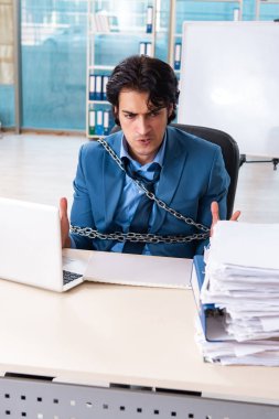 Zincirli erkek çalışan, aşırı çalışmaktan memnun değil. 