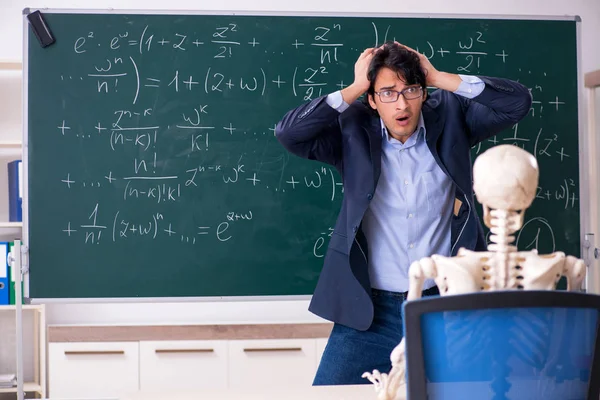 Jeune homme professeur de mathématiques et squelette étudiant — Photo