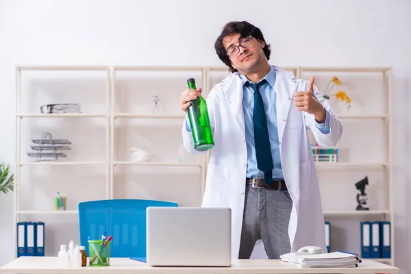 Jonge mannelijke arts drinken in het kantoor — Stockfoto