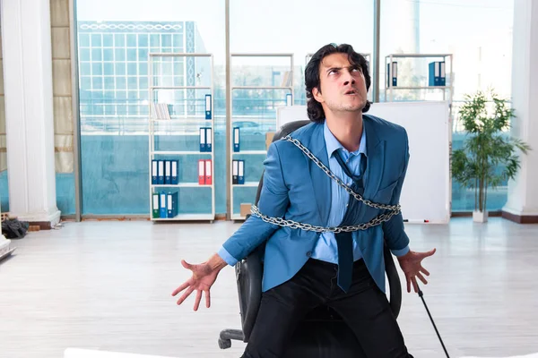 Chained male employee unhappy with excessive work — Stock Photo, Image
