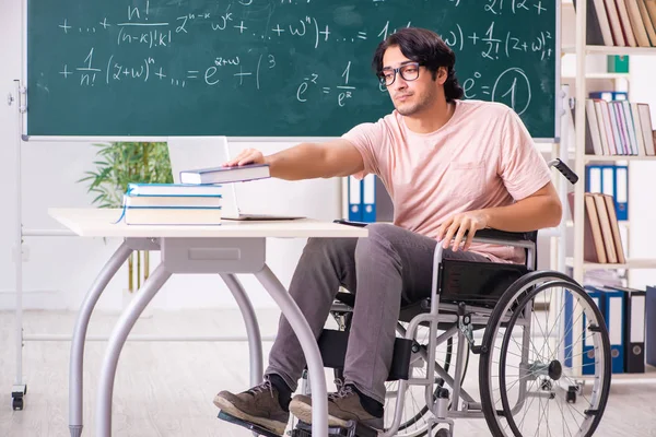 Jonge knappe man in rolstoel voorkant schoolbord — Stockfoto