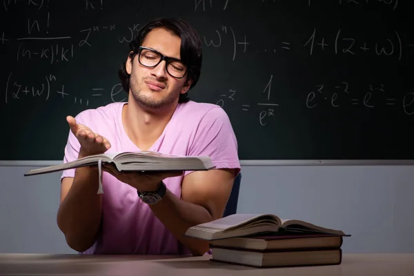 Young male student sitting in classroom — Stock Photo, Image