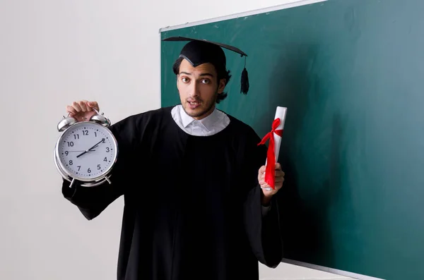 Estudante graduado na frente do quadro verde — Fotografia de Stock