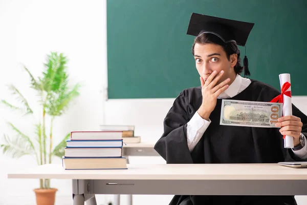 Estudante graduado na frente do quadro verde — Fotografia de Stock