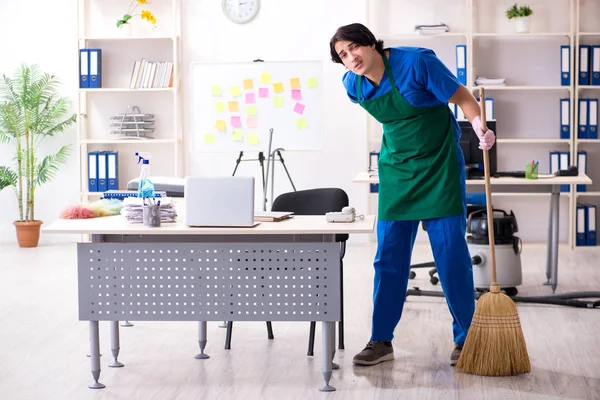 Male handsome professional cleaner working in the office