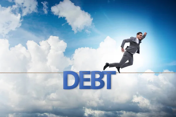 Dług i kredyt koncepcja z biznesmen chodzenie na ciasnej liny — Zdjęcie stockowe