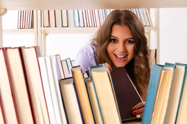 Jonge vrouwelijke student bereidt examens in de bibliotheek voor — Stockfoto