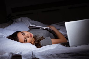Yorgun iş kadını gece fazla mesai yapıyor.
