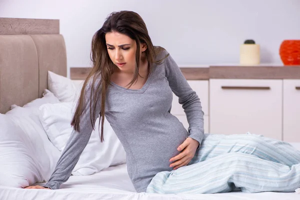 Mujer embarazada joven en el dormitorio — Foto de Stock