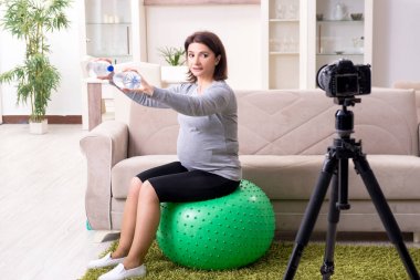Hamile kadın blogcu fiziksel egzersiz yapıyor. 