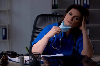 Gece vardiyasında çalışan yaşlı kadın doktor. 