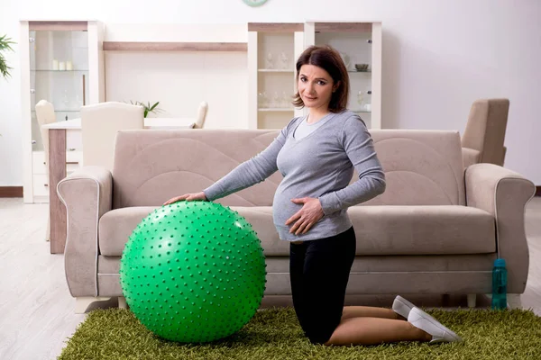 Mulher grávida envelhecida fazendo exercícios em casa — Fotografia de Stock