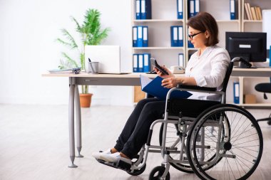 Ofisteki tekerlekli sandalyedeki kadın çalışan.  