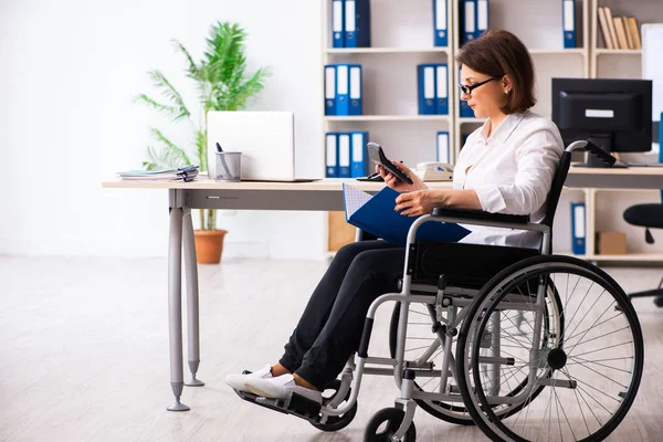 Kobieta na wózku inwalidzkim w biurze — Zdjęcie stockowe