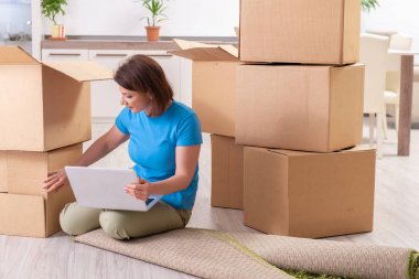 Yeni daire için hareketli orta yaşlı bir kadın 