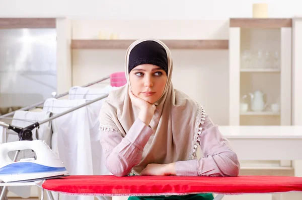 Kvinna i hijab gör kläder strykning hemma — Stockfoto